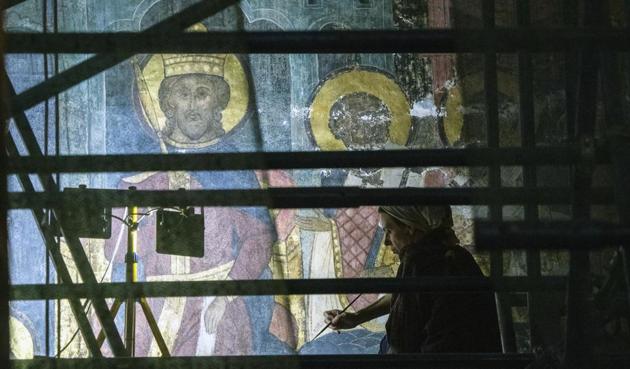 a restorer works inside the Dormition Cathedral in the Kremlin in Moscow, Russia, Friday, July 10, 2020. (AP) a restorer works inside the Dormition Cathedral in the Kremlin in Moscow, Russia, Friday, July 10, 2020. (AP)
