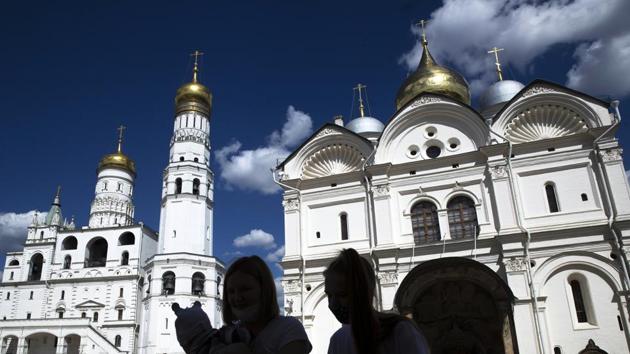 People visit Cathedral Square of the Kremlin in Moscow, Russia, with the Ivan the Great Bell Tower, left and the Cathedral of the Archangel, right in the background, Friday, July 10, 2020. (AP) People visit Cathedral Square of the Kremlin in Moscow, Russia, with the Ivan the Great Bell Tower, left and the Cathedral of the Archangel, right in the background, Friday, July 10, 2020. (AP)