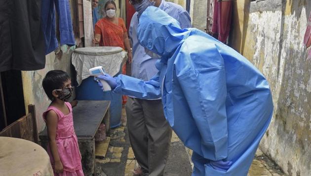 Health care staff check the temperature and pulse rate of the residents of Laxman Nagar at Malad(E) during Covid-19 pandemic in Mumbai on Monday.(Satyabrata Tripathy/HT Photo)