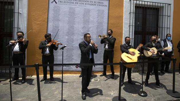 Mexican Mariachi musicians play during a ceremony to mourns 105 Mexican locals that died from COVID-19 complications in the United States, in Puebla, Mexico on July 13. (Fernando Llano / AP) Mexican Mariachi musicians play during a ceremony to mourns 105 Mexican locals that died from COVID-19 complications in the United States, in Puebla, Mexico on July 13. (Fernando Llano / AP)