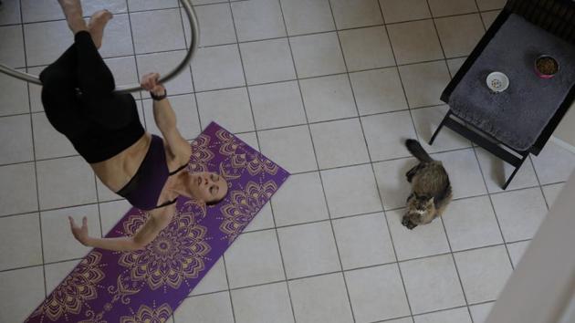 Johanna Sapakie, an aerialist, choreographer and dancer, trains in the living room of her home as her cat watches Sunday, June 21, 2020, in Las Vegas. "You definitely test your willpower," said Sapakie about having to train alone at home without the encouragement she could get at the gym. (AP)