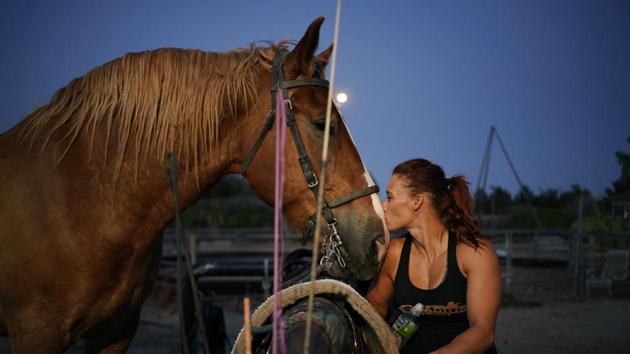 Lisa Varmbo Martonovich kisses a horse while preparing to train for "Gladius The Show," a touring equestrian and acrobatic show, Thursday, May 28, 2020, in Las Vegas. The coronavirus forced the producers to cancel all of their performances through 2020. (AP)