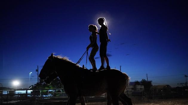 Lisa Varmbo Martonovich, left, and Nicole England-Czyzewski practice roman riding on two horses for "Gladius The Show," a touring equestrian and acrobatic show, Thursday, May 28, 2020, in Las Vegas. The coronavirus forced the producers to cancel all of their performances through 2020. (AP)