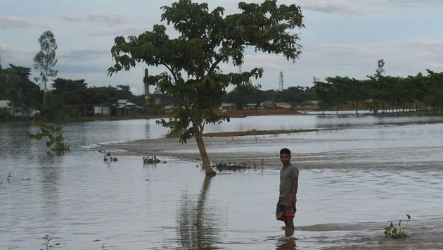 A man stands in the flood waters in Sunamgong on July 14. Flash floods triggered by incessant rainfall have left over 700,000 people marooned in the country. A total of 14 rivers were flowing above the danger level on July 13, according to the Flood Forecasting and Warning Centre. (Munir uz Zaman / AFP) 