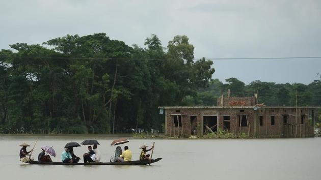 People ride on a boat through flooded waters in Sunamgong on July 14. Bangladesh’s Flood Forecasting and Warning Centre chief Arifuzzaman Bhuiyan told AFP that about a third of flood-prone Bangladesh -- a delta-nation crisscrossed by hundreds of rivers -- was underwater, and at least 1.5 million people were affected, with village homes and roads flooded. (Munir uz Zaman / AFP) 