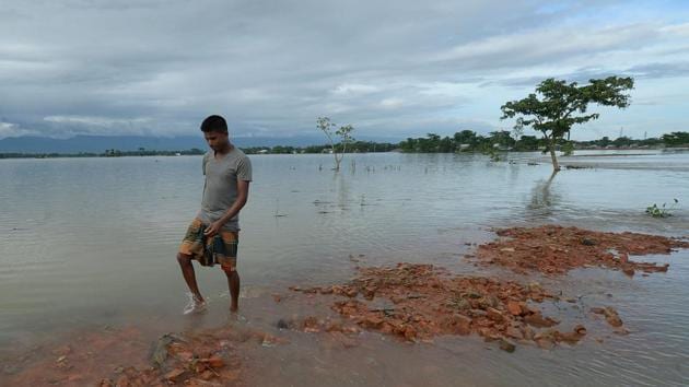 A man walks through flooded waters in Sunamgong on July 14. In north-central Bangladesh, the Brahmaputra river is almost 40 centimetres (16 inches) higher than normal and threatening to burst its banks, district administrator Farook Ahmed told AFP. (Munir uz Zaman / AFP) 