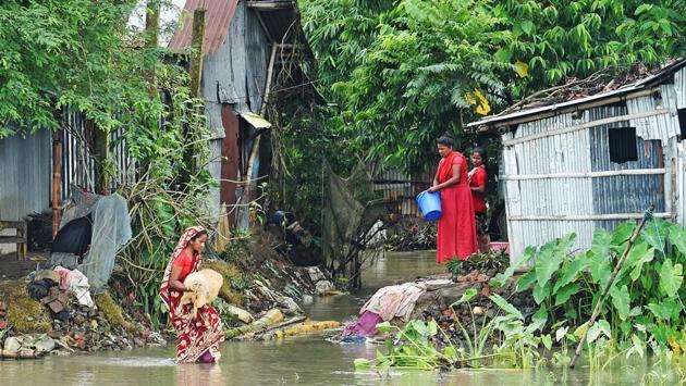 A woman carries a sheep as she makes her way through flood waters in Sunamgong on July 15. Most villagers are trying to stay near their flood-damaged homes, but some 15,000 have fled severely affected areas, officials told AFP. (Munir uz Zaman / AFP) 