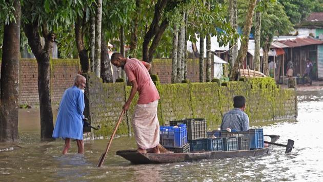 People make their way through flood waters in Sunamgong on July 15. With a 10-day forecast pointing to rising waters, Bhuiyan said if more rivers burst their banks some 40% of the nation could be flooded “in a worst-case scenario”. (Munir uz Zaman / AFP) 