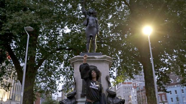 Jen Reid poses for photographs in front of the new black resin and steel statue portraying her entitled "A Surge of Power (Jen Reid) 2020" by artist Marc Quinn after the statue was put up this morning on the empty plinth of the toppled statue of 17th century slave trader Edward Colston, which was pulled down during a Black Lives Matter protest in Bristol, England, Wednesday, July 15, 2020. On June 7 anti-racism demonstrators pulled the 18-foot (5.5 meter) bronze likeness of Colston down, dragged it to the nearby harbor and dumped it in the River Avon — sparking both delight and dismay in Britain and beyond.(AP) Jen Reid poses for photographs in front of the new black resin and steel statue portraying her entitled "A Surge of Power (Jen Reid) 2020" by artist Marc Quinn after the statue was put up this morning on the empty plinth of the toppled statue of 17th century slave trader Edward Colston, which was pulled down during a Black Lives Matter protest in Bristol, England, Wednesday, July 15, 2020. On June 7 anti-racism demonstrators pulled the 18-foot (5.5 meter) bronze likeness of Colston down, dragged it to the nearby harbor and dumped it in the River Avon — sparking both delight and dismay in Britain and beyond.(AP)