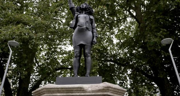 A new black resin and steel statue entitled "A Surge of Power (Jen Reid) 2020" by artist Marc Quinn stands after the statue was put up this morning on the empty plinth of the toppled statue of 17th century slave trader Edward Colston, which was pulled down during a Black Lives Matter protest in Bristol, England. (AP)