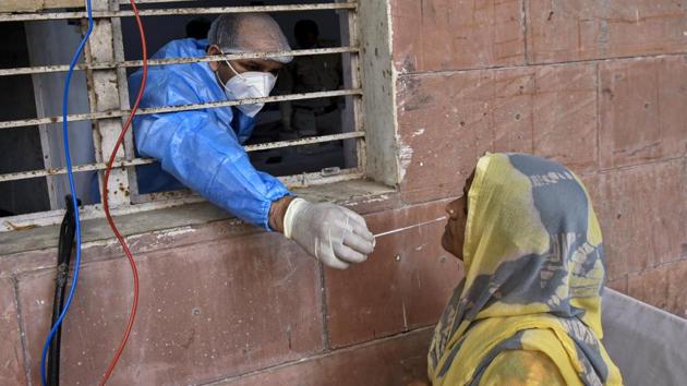 A health worker collects a swab sample from a woman to test for Covid-19 infection at a dispensary in Okhla, New Delhi on Tuesday.(Biplov Bhuyan/HT PHOTO)