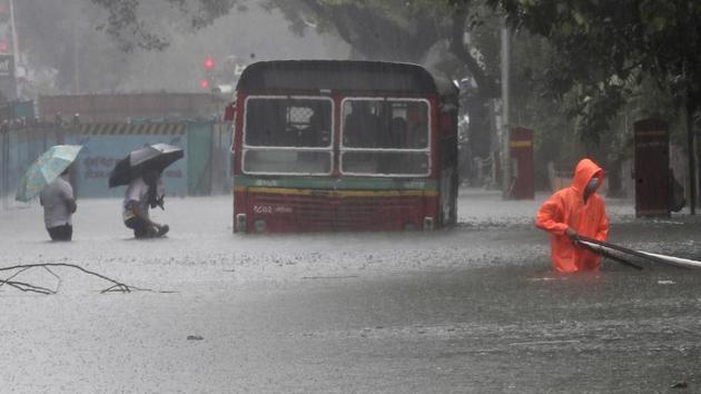 People make their way past a BEST bus that broke down in the rain on July 15. Mumbai had received 910.2 mm of rains between July 1 and 15 until 2:30pm, against the month’s average rainfall of 840.7 mm, or 108%, to date. The city has also met 58% of its seasonal rainfall target. (Rafiq Maqbool / AP) People make their way past a BEST bus that broke down in the rain on July 15. Mumbai had received 910.2 mm of rains between July 1 and 15 until 2:30pm, against the month’s average rainfall of 840.7 mm, or 108%, to date. The city has also met 58% of its seasonal rainfall target. (Rafiq Maqbool / AP)