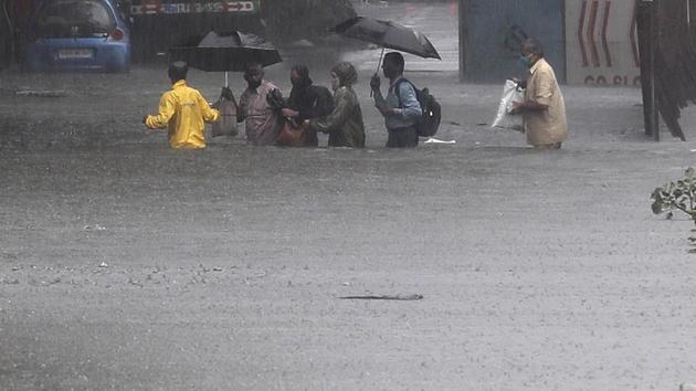 People navigate their way through a waterlogged street after their bus broke down during heavy rainfall in Mumbai on July 15. The IMD had also predicted the possibility of very high, or over three feet deep, flooding across 29 of 656 locations in 24 wards of the Brihanmumbai Municipal Corporation (BMC). (Rafoq Maqbool / AP) People navigate their way through a waterlogged street after their bus broke down during heavy rainfall in Mumbai on July 15. The IMD had also predicted the possibility of very high, or over three feet deep, flooding across 29 of 656 locations in 24 wards of the Brihanmumbai Municipal Corporation (BMC). (Rafoq Maqbool / AP)