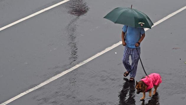 A man walks his dog in the rain on July 15. The weather bureau suggests action in the form of proper regulation of traffic and restricted movement of the public in affected areas, especially low-lying zones under such weather conditions. (Punit Paranjpe / AFP) A man walks his dog in the rain on July 15. The weather bureau suggests action in the form of proper regulation of traffic and restricted movement of the public in affected areas, especially low-lying zones under such weather conditions. (Punit Paranjpe / AFP)