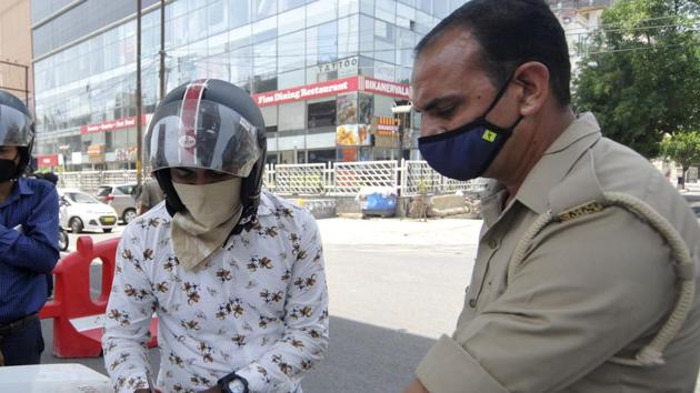Police officials fine a commuter during lockdown, at Sector 18, in Noida. (Sunil Ghosh / Hindustan Times) Police officials fine a commuter during lockdown, at Sector 18, in Noida. (Sunil Ghosh / Hindustan Times)
