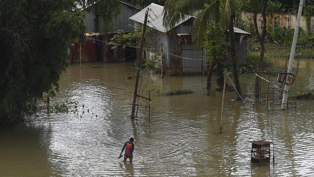 A man walks through flooded waters in Sunamgong on July 14. The monsoon -- which usually falls from June to September -- is crucial to the economy of countries in the Indian sub-continent, but also causes widespread death and destruction across the region each year. (Munir uz Zaman / AFP) 