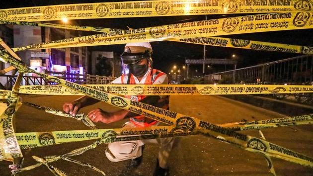 A traffic cop seals a road ahead of total lockdown, during Unlock 2.0 in Bengaluru on Tuesday.(PTI Photo)