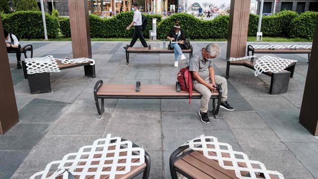 People relax in a public space with some benches closed due to government social distancing measures in Hong Kong on July 15. The city reimposed tough social distancing measures -- shuttering many businesses and making face masks on public transport mandatory -- after a spike in coronavirus cases threatened to undo months of success against the disease. (Anthony Wallace / AFP) People relax in a public space with some benches closed due to government social distancing measures in Hong Kong on July 15. The city reimposed tough social distancing measures -- shuttering many businesses and making face masks on public transport mandatory -- after a spike in coronavirus cases threatened to undo months of success against the disease. (Anthony Wallace / AFP)