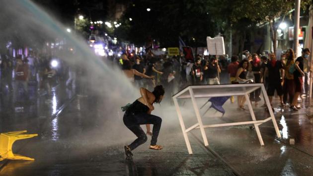 A protester slips as Israeli police use water cannons to disperse protestors on July 14. The demonstrators have staged a sit-in outside Netanyahu’s official residence in Jerusalem for the past month, calling on him to resign. They told AP that police used excessive force to dismantle the sit-in while opposition politicians decried the move as a restriction of free expression. (Menahem Kahana / AFP)