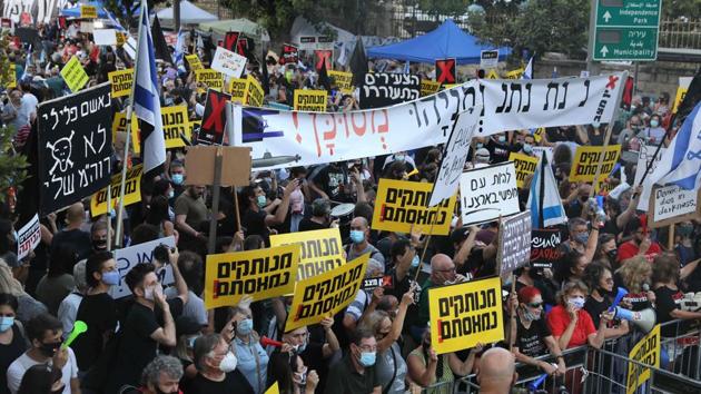 Israelis wear face masks to prevent the spread of coronavirus during a protest against Prime Minister Benjamin Netanyahu outside his residence in Jerusalem, on July 14. Rampantly spreading coronavirus, unemployment over 21% and the corruption allegations have come together in a rare widespread discontent with Prime Minister Benjamin “Bibi” Netanyahu. (Menahem Kahana / AFP)