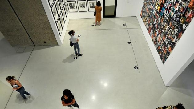 Visitors stand next to social distancing markers as they view photographs in the exhibition 'Masculinities' at the Barbican arts centre. (REUTERS/Toby Melville) Visitors stand next to social distancing markers as they view photographs in the exhibition 'Masculinities' at the Barbican arts centre. (REUTERS/Toby Melville)