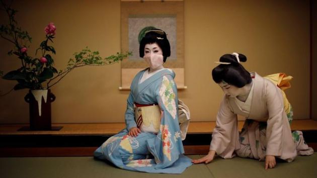 Koiku, who is a geisha, is seen wearing a protective face mask while her colleague Mayu adjusts her kimono before a performance in Tokyo on June 23. The number of geisha - famed for their witty conversation, beauty and skill at traditional arts - has been falling for years. Moreover, due to the coronavirus outbreak, many of them have been without work for months and now operate under awkward social distancing rules. (Kim Kyung-Hoon / REUTERS) Koiku, who is a geisha, is seen wearing a protective face mask while her colleague Mayu adjusts her kimono before a performance in Tokyo on June 23. The number of geisha - famed for their witty conversation, beauty and skill at traditional arts - has been falling for years. Moreover, due to the coronavirus outbreak, many of them have been without work for months and now operate under awkward social distancing rules. (Kim Kyung-Hoon / REUTERS)