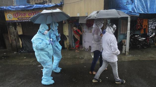 Health workers leave after screening people for Covid-19 symptoms in Mumbai (AP) Health workers leave after screening people for Covid-19 symptoms in Mumbai (AP)
