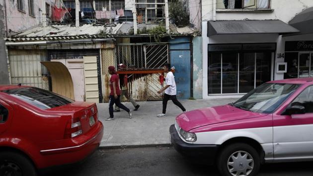 Brothers Alexis De Jesus Nanguelu, 23, left, and Cristhian Omar Nanguelu, 17, right, carry a marimba with the help of their uncle Arturo Lezama as they visit different blocks of the Roma Norte neighborhood, playing traditional music to earn occasional tips of coins tossed from apartment windows by appreciative residents. (AP Photo/Rebecca Blackwell) Brothers Alexis De Jesus Nanguelu, 23, left, and Cristhian Omar Nanguelu, 17, right, carry a marimba with the help of their uncle Arturo Lezama as they visit different blocks of the Roma Norte neighborhood, playing traditional music to earn occasional tips of coins tossed from apartment windows by appreciative residents. (AP Photo/Rebecca Blackwell)