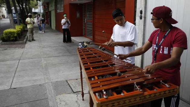 Brothers Alexis De Jesus Nanguelu, 23, right, and Cristhian Omar Nanguelu, 17, perform on the marimba in hopes of tips from appreciative residents, in the Roma Norte neighborhood of Mexico City. (AP Photo/Rebecca Blackwell) Brothers Alexis De Jesus Nanguelu, 23, right, and Cristhian Omar Nanguelu, 17, perform on the marimba in hopes of tips from appreciative residents, in the Roma Norte neighborhood of Mexico City. (AP Photo/Rebecca Blackwell)