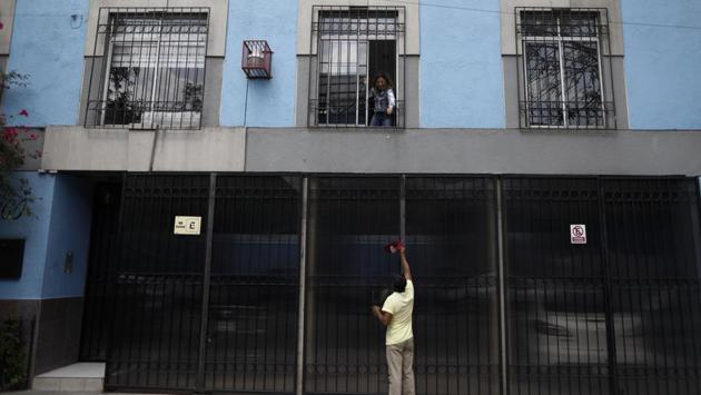 A resident drops a coin down to Arturo Lezama, as his nephews, unseen, play a marimba on the street outside, in the Roma Norte neighbourhood of Mexico City. (AP Photo/Rebecca Blackwell) A resident drops a coin down to Arturo Lezama, as his nephews, unseen, play a marimba on the street outside, in the Roma Norte neighbourhood of Mexico City. (AP Photo/Rebecca Blackwell)