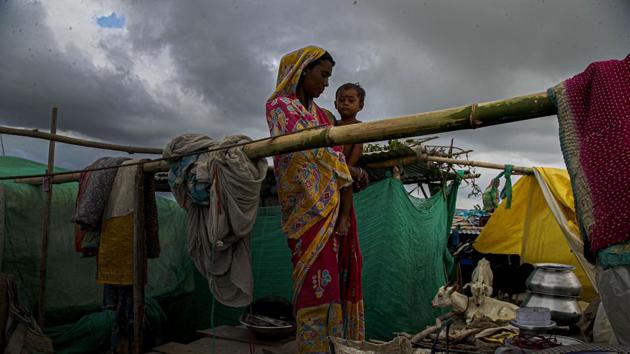 A woman and child take shelter at a temporary structure near their submerged house along the river Brahmaputra in Morigaon district, Assam on July 16. Dhubri is the worst hit district with over 8.72 lakh people affected, followed by Barpeta with more than 4.78 lakh people and Goalpara with around 4.28 lakh people. (Anupam Nath / AP)