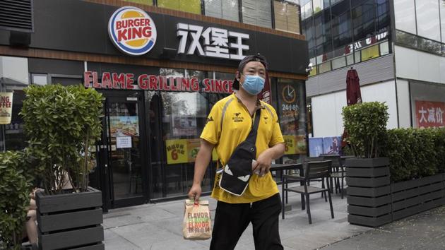 A delivery person walks out of a Burger King store in Beijing on July 17. Retail sales shrank by 3.9%, but that was a marked improvement over the previous quarter’s 19% contraction when millions of families had been confined to their homes and shopping malls were shut down. (Ng Han Guan / AP) A delivery person walks out of a Burger King store in Beijing on July 17. Retail sales shrank by 3.9%, but that was a marked improvement over the previous quarter’s 19% contraction when millions of families had been confined to their homes and shopping malls were shut down. (Ng Han Guan / AP)