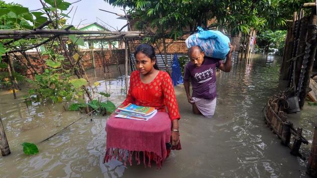 Villagers relocate to a safer place from the flooded area of Hatisela in Kamrup district on July 14. 3,218 villages are under water and 131,368.27 hectares of crop areas have been damaged across Assam as of July 16, the ASDMA has said. (PTI)