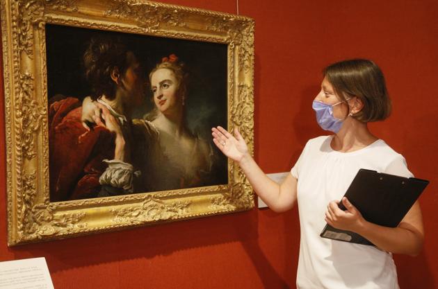 Kateryna Chyeva, head of the Khanenko Family National Museum, wearing face mask to protect against coronavirus views "An Amorous Couple" by 18th century French artist Pierre Louis Goudreaux in the Khanenko Family National Museum in Kyiv, Ukraine, Tuesday, July 14, 2020. (AP)
