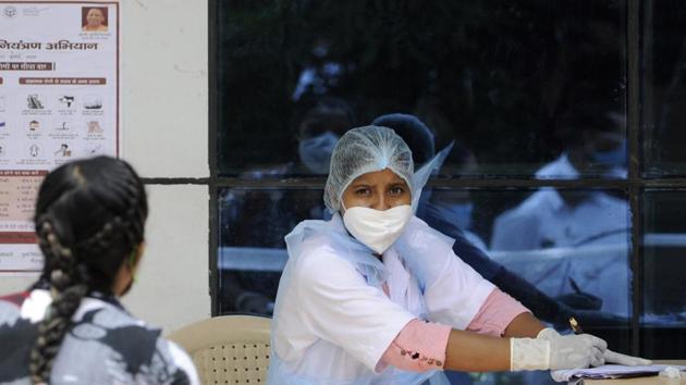 A health worker notes down details of people waiting for coronavirus tests in Noida. (Sunil Ghosh / Hindustan Times) A health worker notes down details of people waiting for coronavirus tests in Noida. (Sunil Ghosh / Hindustan Times)