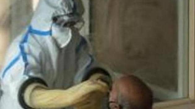 A health worker collects a swab sample from a man to test for Covid-19 infection. (HT photo) A health worker collects a swab sample from a man to test for Covid-19 infection. (HT photo)