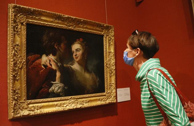 A visitor wearing a face mask to protect against coronavirus views "An Amorous Couple" by 18th century French artist Pierre Louis Goudreaux in the Khanenko Family National Museum in Kyiv, Ukraine, Tuesday, July 14, 2020. (AP)