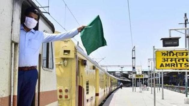 A Indian Railways guard waves the green flag aboard a Jaynagar-Shaheed Express train at the Amritsar Junction in this file photo.(HT Poto/Sameer Sehgal)