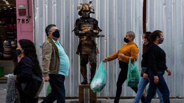 People wearing face masks walk in 25 de Marco, a popular shopping street in Sao Paulo on July 16. Brazil’s roughly 7,000 COVID-19 deaths in each of the last seven weeks is equal to several aeroplanes packed with Brazilians crashing every day, former health minister Luiz Henrique Mandetta told The Associated Press. (Alexandre Schneider / Getty Images)