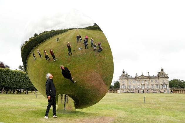 British-Indian artist Anish Kapoor is reflected in one of his sculptures as he poses for photographs in the gardens at Houghton Hall in Norfolk, Britain July 9, 2020. (REUTERS)