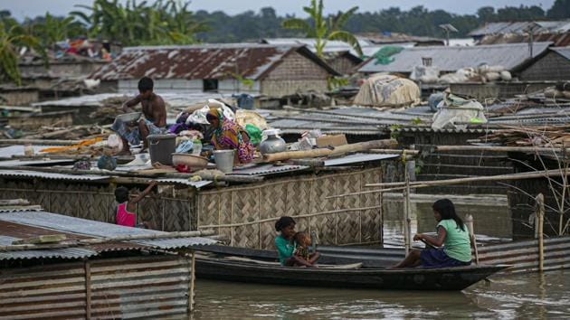 A flood affected family takes shelter on the roof of their partially submerged house along river Brahmaputra in Morigaon district, Assam. (AP) A flood affected family takes shelter on the roof of their partially submerged house along river Brahmaputra in Morigaon district, Assam. (AP)
