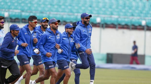 India's Ravindra Jadeja, right, jumps up as he runs with teammates during a practice session in Dharmsala.(AP)