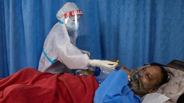 A medical worker wearing personal protective equipment (PPE) tends to a patient suffering from the coronavirus disease (COVID-19), in the Intensive Care Unit (ICU) at Lok Nayak Jai Prakash (LNJP) hospital, in New Delhi.(REUTERS) A medical worker wearing personal protective equipment (PPE) tends to a patient suffering from the coronavirus disease (COVID-19), in the Intensive Care Unit (ICU) at Lok Nayak Jai Prakash (LNJP) hospital, in New Delhi.(REUTERS)