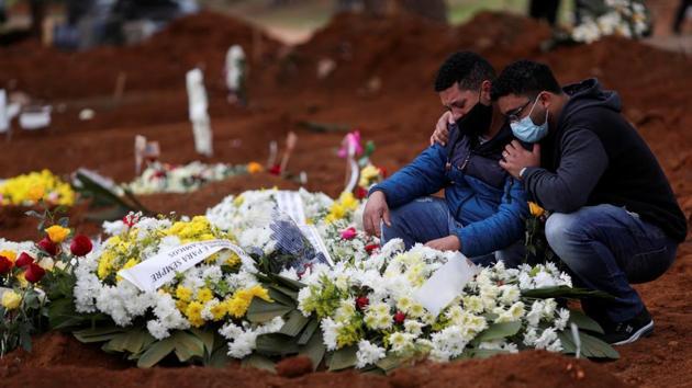 Relatives react near the grave of Neusa Freitas dos Santos, 81, who died from the coronavirus disease (COVID-19) after the burial at Vila Formosa cemetery, in Sao Paulo, Brazil on July 16. Brazil, the largest country in South America has passed 2 million confirmed cases of coronavirus infections and logged over 77,000 lives lost to the Covid-19 disease. (Amanda Perobelli / REUTERS)