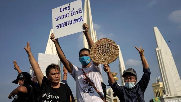 Protesters hold a sign that reads, "The longer you stay, the more devastation to the country, please resign" as they take part in an anti-government demonstration in Bangkok. (AFP)