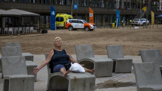A woman relaxes on a bench with her arms open near a beach in Barcelona, Spain on July 16. Many hard-hit countries have “flattened the curve” and are easing lockdowns while others, such as the cities of Barcelona and Melbourne, are implementing a second round of local shutdowns. (Emilio Morenatti / AP) A woman relaxes on a bench with her arms open near a beach in Barcelona, Spain on July 16. Many hard-hit countries have “flattened the curve” and are easing lockdowns while others, such as the cities of Barcelona and Melbourne, are implementing a second round of local shutdowns. (Emilio Morenatti / AP)