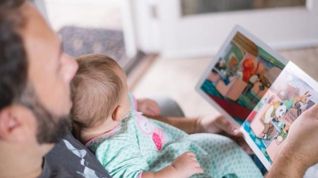 A father reads a picture book along with his toddler. (Representational Image)(Unsplash)