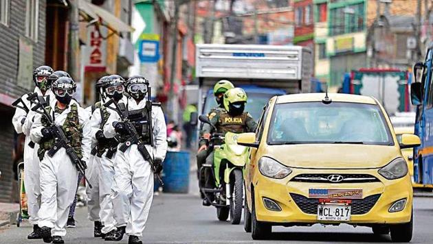 BOOTS ON THE GROUND: Soldiers in protective gear patrol the streets of the bustling neighbourhood of Ciudad Bolivar, an area with high cases of the coronavirus, in Bogota, Colombia. (AP) BOOTS ON THE GROUND: Soldiers in protective gear patrol the streets of the bustling neighbourhood of Ciudad Bolivar, an area with high cases of the coronavirus, in Bogota, Colombia. (AP)