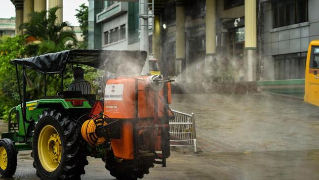 Greater Chennai Corporation workers spray disinfectant in the premises of Rajiv Gandhi Government General Hospital during an intensified lockdown imposed to curb the spread of coronavirus disease in Chennai on Sunday.(PTI Photo)