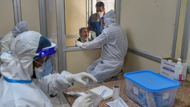 Health workers working at a COVID-19 rapid antigen testing booth in New Delhi on July 18. As per ICMR guidelines, symptomatic persons who test negative in the rapid antigen tests should be followed up with an RT-PCR test. (Kamal Kishore / PTI) Health workers working at a COVID-19 rapid antigen testing booth in New Delhi on July 18. As per ICMR guidelines, symptomatic persons who test negative in the rapid antigen tests should be followed up with an RT-PCR test. (Kamal Kishore / PTI)